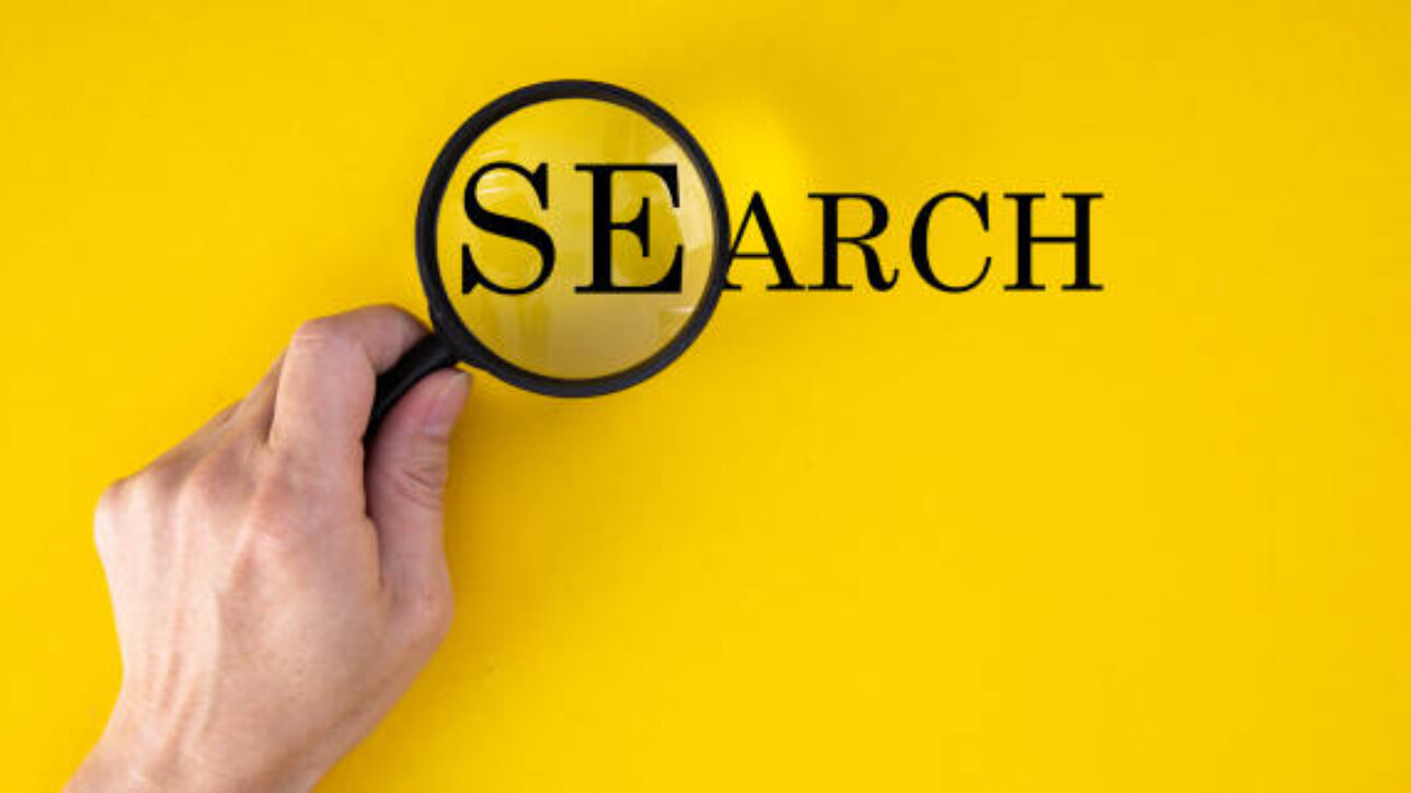 job search concept, inscription and magnifier in hand on a yellow background